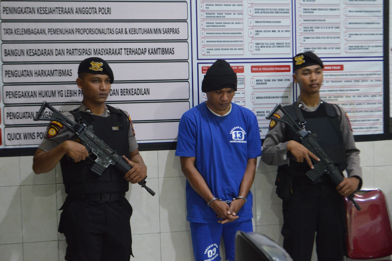 PENGGELAPAN: Pelaku penggelapan mobil rental inisial AN, 38, dikawal polisi bersenjata saat gelar perkara di Aula Mapolres Magelang Kota. (Foto: Humas Polres Magelang Kota)