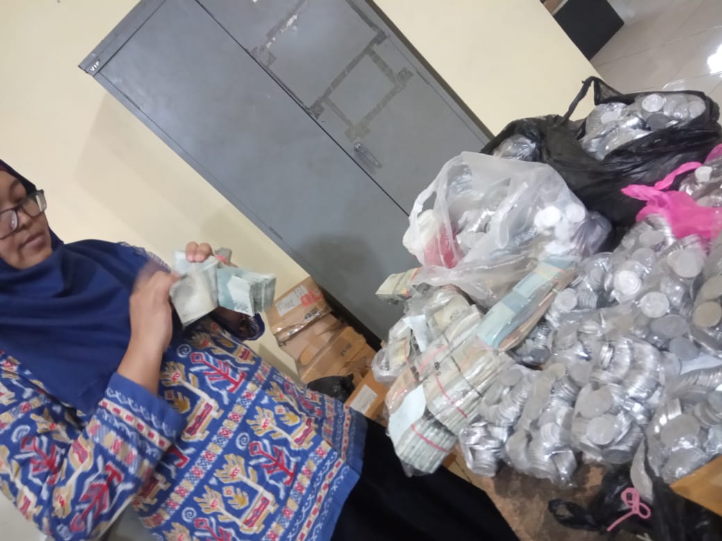NEWS: Pegawai dealer sedang menghitung uang receh milik warga Salaman untuk membeli sepeda motor (22/1/2020)-(Foto: istimewa)