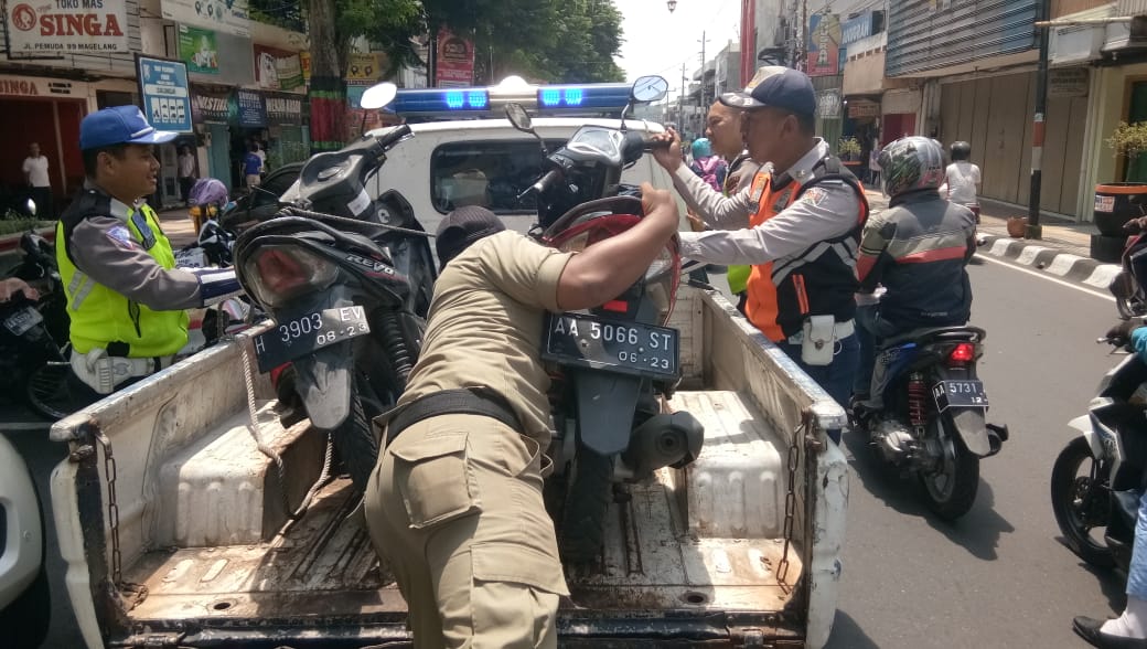 DIANGKUT: Petugas Gabungan Operasi KTL mengamankan dua sepeda motor yang melanggar. (Foto: Satpol PP Kota Magelang)