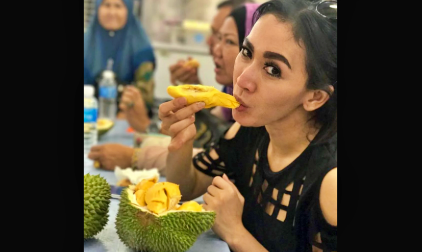 ILUSTRASI : Seorang perempuan makan durian Indonesia (Foto: Internet)