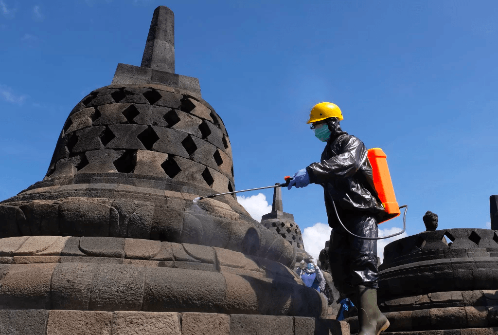 SEMPROT: Seorang petugas sedang menyemprotkan cairan disinfektan pada bagian stupa Candi Borobudur di Kabupaten Magelang. (Foto: Istimewa)