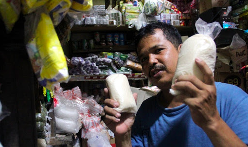MANIS: Pedagang sembako dengan gula pasir yang dijualnya. (Foto: Istimewa)