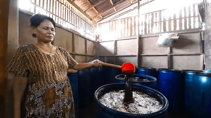KREATIF: Perajin minuman keras tradisional menunjukkan ciu yang nantinya akan diolah menjadi hand sanitizer. (Foto: Istimewa)
