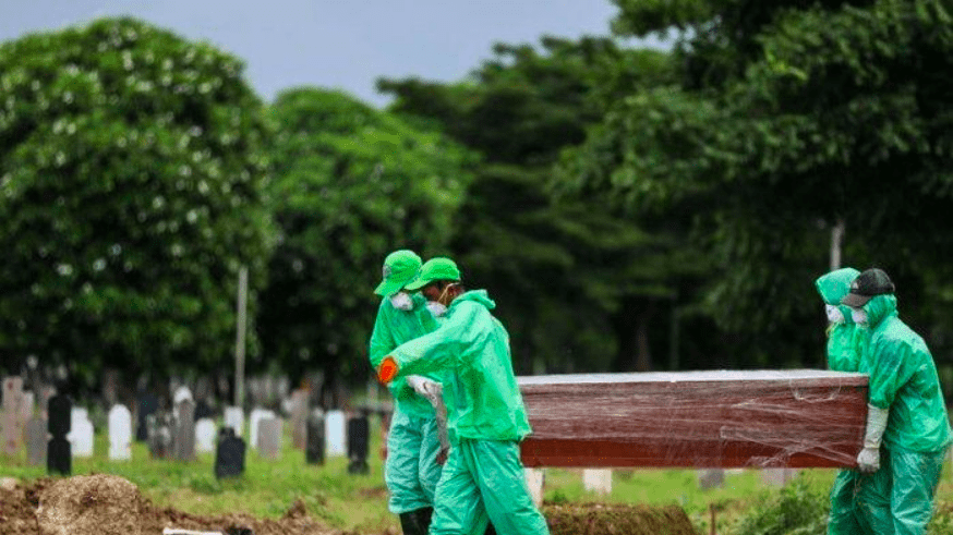 PEMAKAMAN: Empat orang petugas menggotong peti mati yang berisi jenazah positif Covid-19. (Foto: Internet)