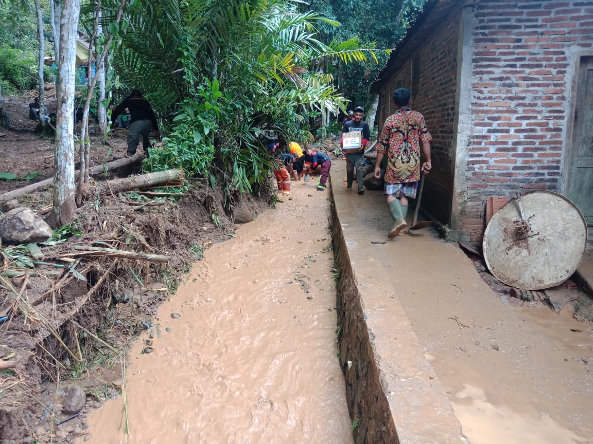 NEWS: Warga korban banjir bandang sedang membersihkan saluran sungai di tengan kampung (2/3/2020)-(Foto: cr1)