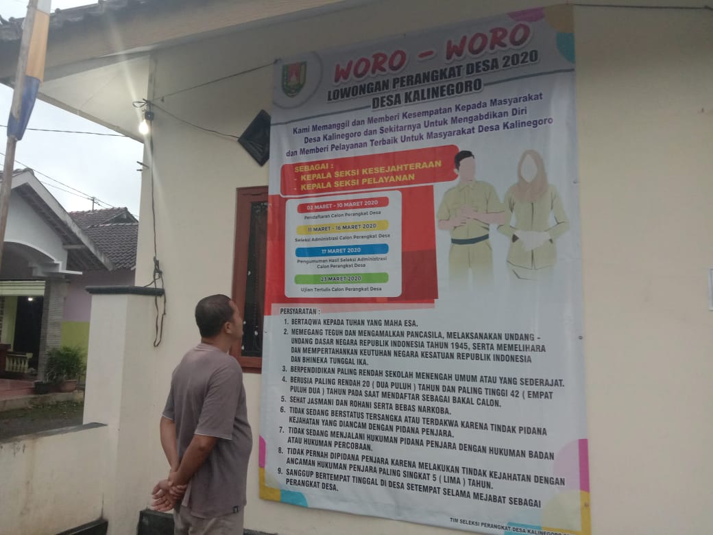NEWS: Salah satu warga sedang membca pengumuman lowongan menjadi perangkat desa di Kalinegoro Mertoyudan (9/3/2020)-(Foto: Istimewa)
