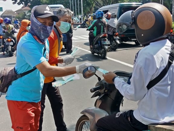 KEMANUSIAAN: Gabungan relawan dan komunitas Magelang Raya membagikan ratusan masker serta vitamin gratis ke pengendara, Sabtu (21/3). (Foto: miftakhul Hayu Jatiningtias)