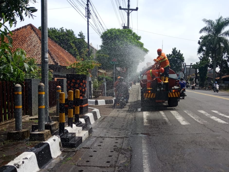 SORRR: Petugas Damkar Kota Magelang menyemprotkan disinfektan ke jalan dan trotoar untuk cegah persebaran Korona, Selasa (24/3). (Foto: Miftakhul Hayu Jatiningtias)