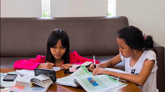 FOKUS: Dua siswa menonton video belajar digital dari rumah. (Foto: Internet)