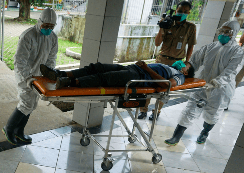 EVAKUASI: Petugas medis mengevakuasi satu orang PDP Covid-19 baru menuju rumah sakit rujukan. (Foto: Ilustrasi)
