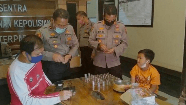 PECAH CELENGAN: Polisi menghitung uang receh donasi dari Mochammad Hafidh untuk membeli APD. (Foto: Istimewa)