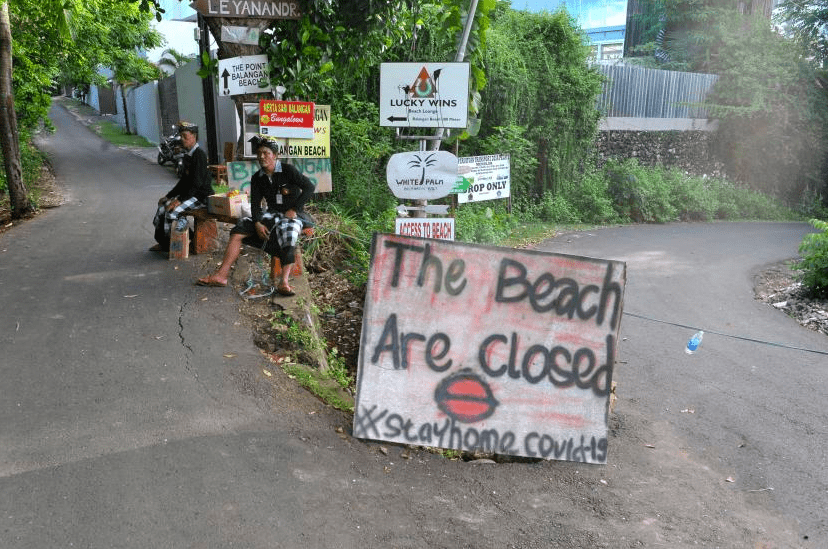 CLOSED: Pecalang atau petugas pengamanan adat Bali berjaga di sekitar kawasan wisata Pantai Balangan yang ditutup sementara di Badung akibat pandemi covid-19. (Foto: Internet)