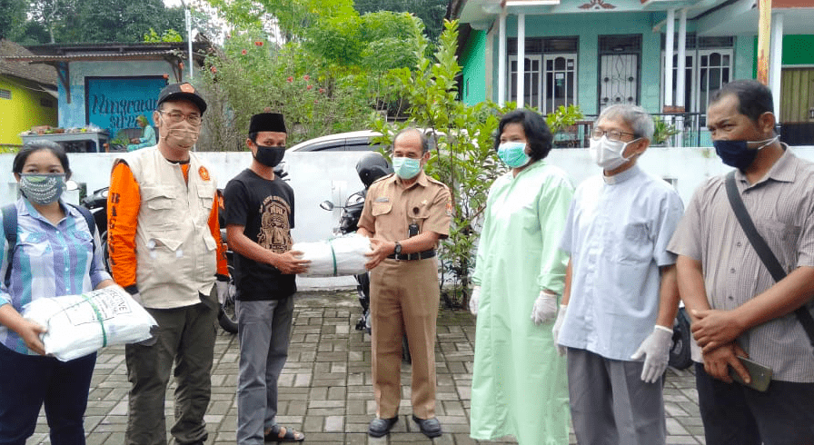SILATURAHMI: PAC GP Ansor dan Pemuda Katolik Srumbung menyerahkan bantuan APD baju hazmat bagi tenaga medis di puskesmas setempat, Selasa (21/4). (Foto: han)