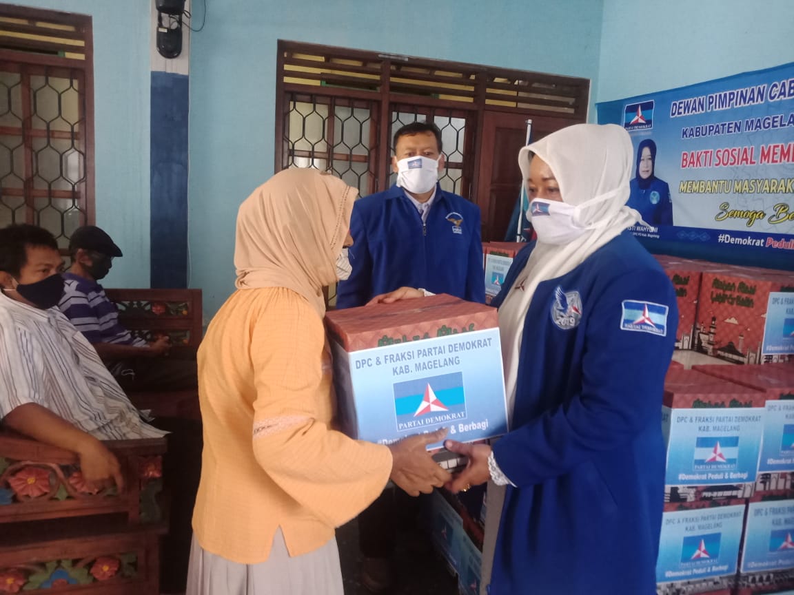 BERBAGI: Ketua DPC Partai Demokrat Kabupaten Magelang Isti Wahyuni menyerahkan bantuan paket sembako ke warga terdampak covid-19, Minggu (10/5). (Foto: mta)