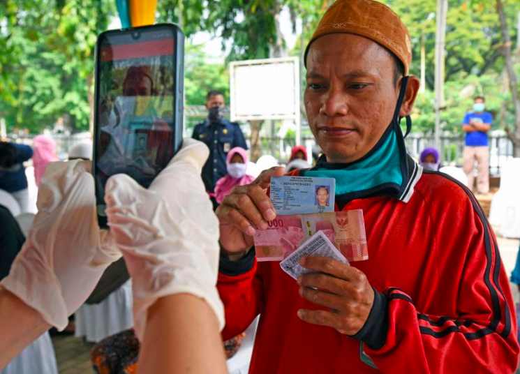 ALHAMDULILLAH: Seorang penerima bantuan didokumentasikan oleh petugas saat menerima bantuan. (Foto: internet)