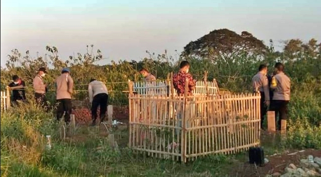 Petugas kepolisian saat lakukan olah TKP di sebuah makam yang dua kuburannya dibongkar (18/7/2020)-(Foto: Istimewa)