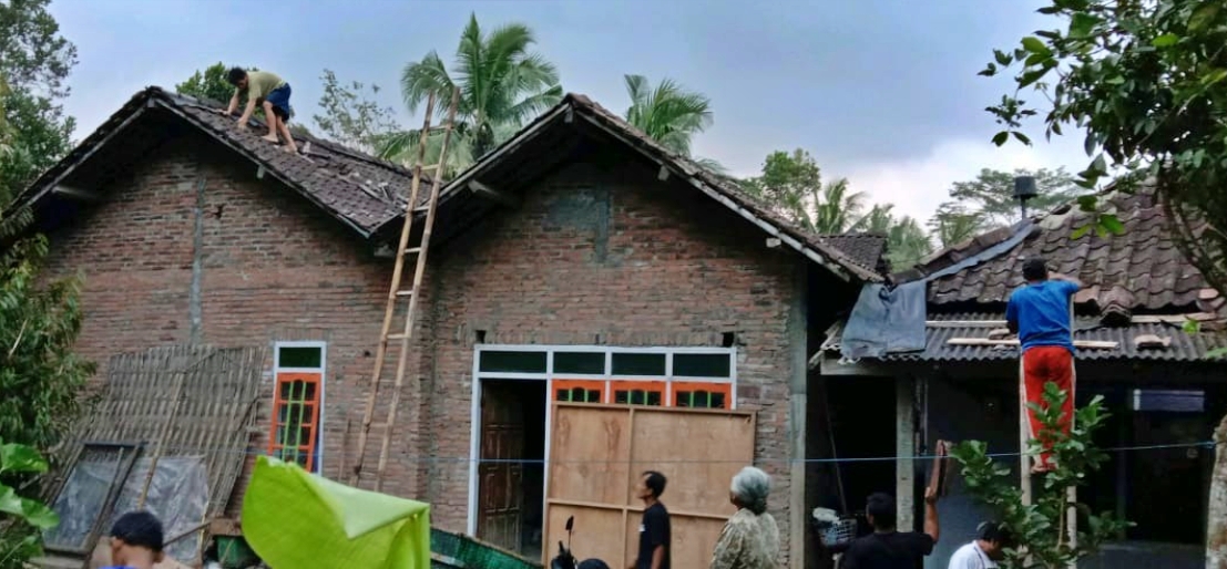 Warga Tempuran saat memperbaiki atap rumah yang berhamburan diterjang angin kencang (14/8/2020)