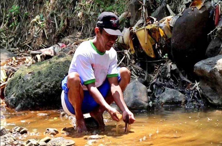 warga saat menunjukan air di aliran sungai elo yang tercemar limah pabrik (9/9/2020)-(Foto: Antara)