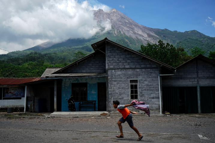 SIAGA: Seorang anak bermain dengan latar belakang Gunung Merapi di kawasan Kinahrejo, Cangkringan, Sleman, DI Jogjakarta, Rabu (18/11/). (Gamvar: ilustrasi)