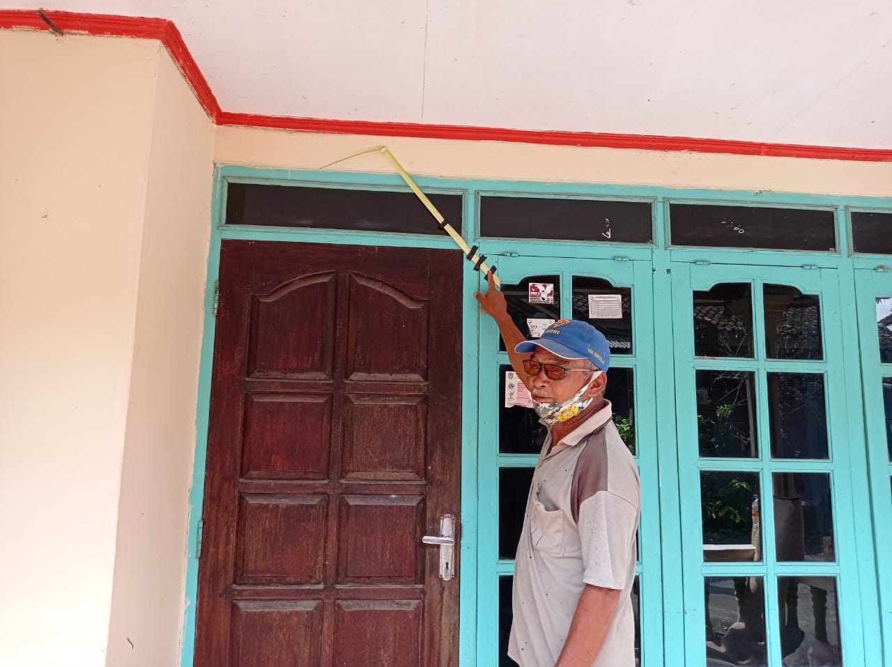 Salah satu warga menunjukan janur kuning yang di pasang di teras rumah (21/11/2020)-(foto: bsn)