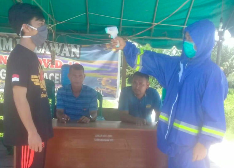 CEK: Seorang warga dicek suhu tubuh dengan thermo tembak di posko setempat. (gambar: internet)
