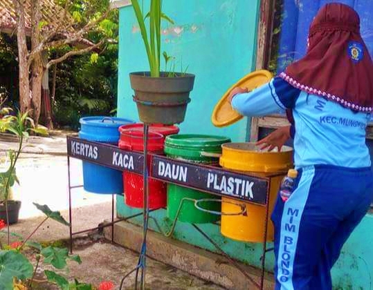 Salah satu siswa MI Muhammadiyah Blondo saat membuang sampah di sekitar rumahnya
