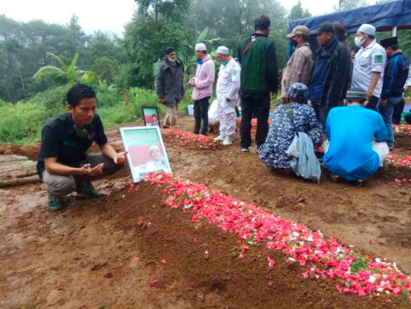 ZIARAH: Salah satu pelayat di pusara pengawal Rizieq Shihab yang meninggal ditembak polisi. (foto: internet)