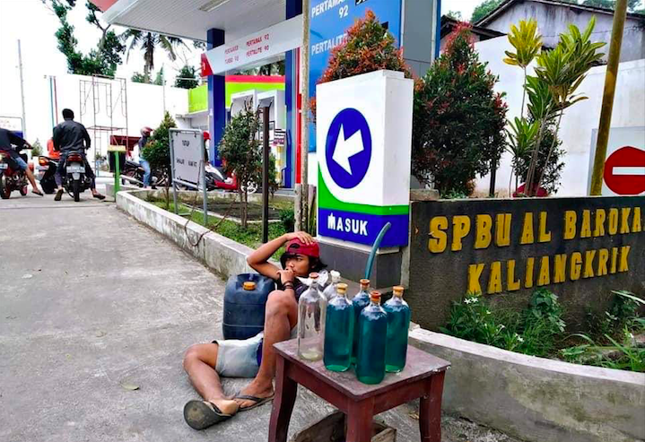 GA PUNYA AKHLAK: Seorang pemuda yang belum diketahui identitasnya menggelar lapak bensin eceran di depan SPBU Kaliangkrik, Kabupaten Magelang. (foto: dok pribadi)