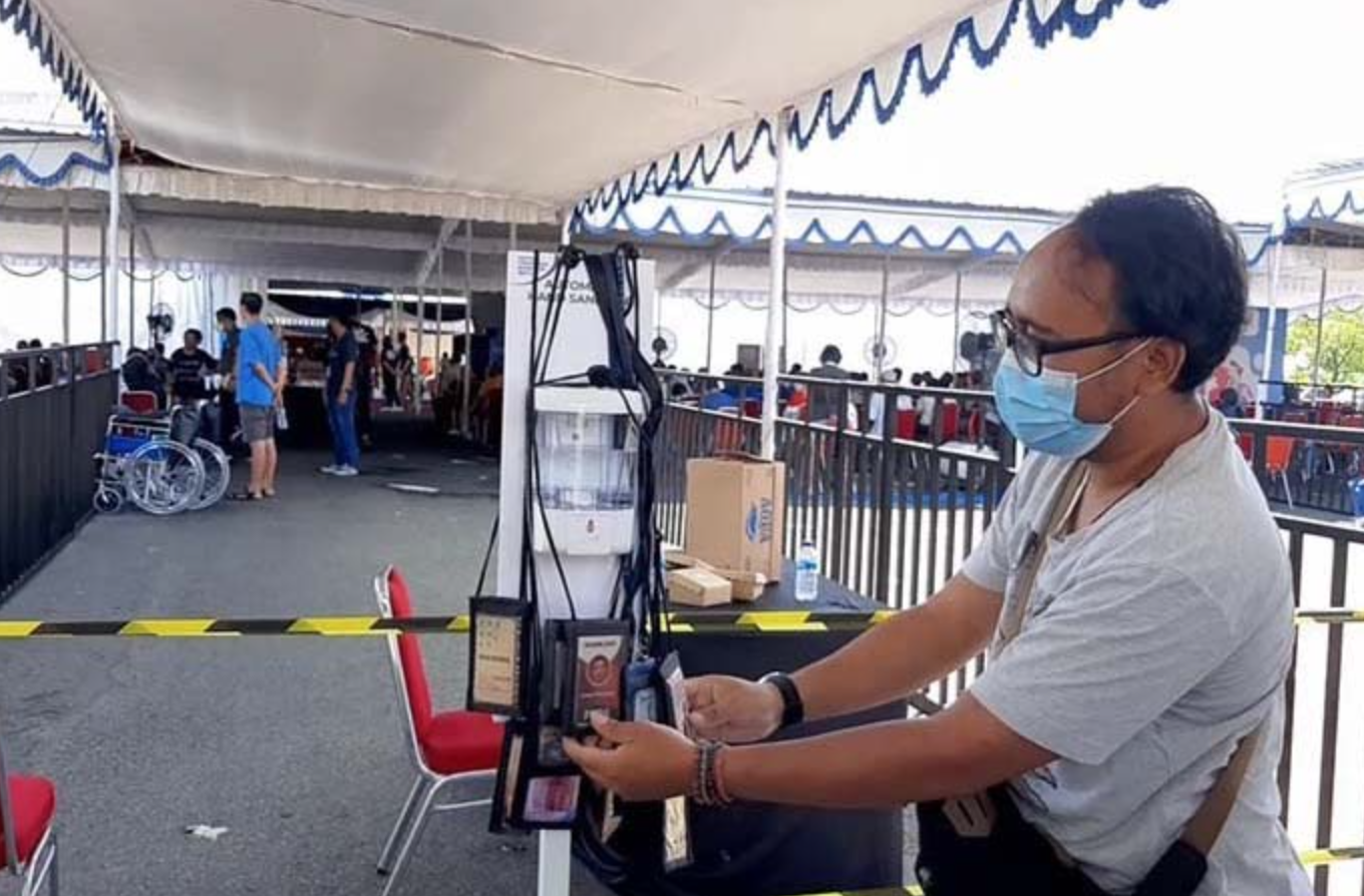 PROTES: Salah seorang wartawan menggantungkan kartu pers diesla kegiatan vaksinasi covid-19 bagi lansia di Banyumas, Rabu (31/3).(foto: ist)