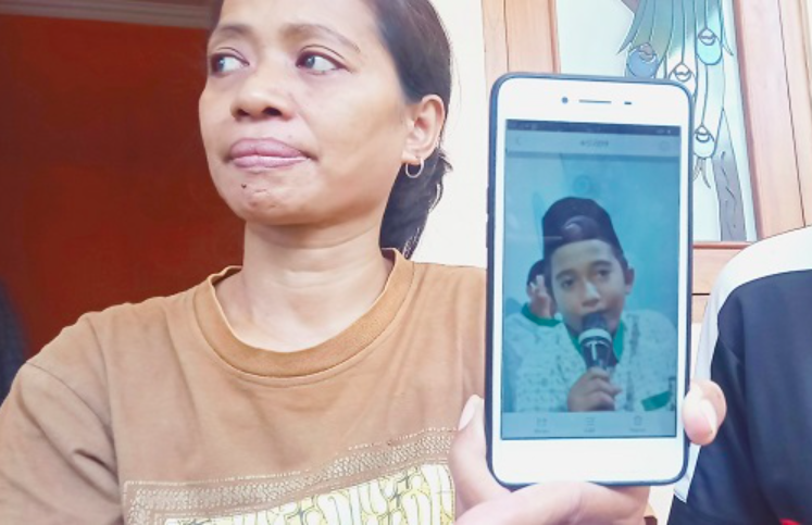 INSYAALLAH SURGA: Ibunda korban, Titik Rini, menunjukkan foto putranya, Naba Faiz Prasetya. (foto: ist)