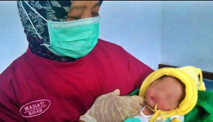 Bidan Desa saat menggendong Bayi yang dibuang oleh Gadis 22 tahun yang merupakan ibunya