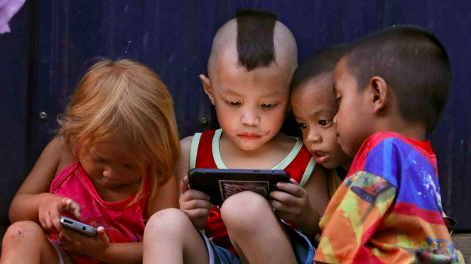 Anak-anak sedang bermain handphone. (gambar: ilustrasi/internet)