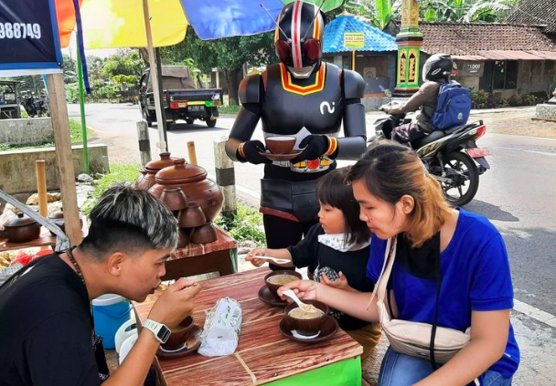 KREATIF: Wahyu Prasetyo, 31, berkosum Satria Baja Hitam berjualan es cendol di Jogja. (foto: ist)