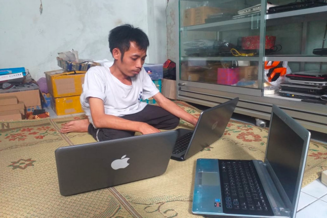 KELEBIHAN: Khoirus Syuaib, 31, tengah mereparasi laptop pelanggannya. (foto: ist)