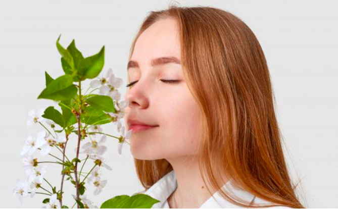 INDRA PENCIUMAN: Seorang wanita sedang menghirup bau wangi semerbak kembang. (foto: ist)