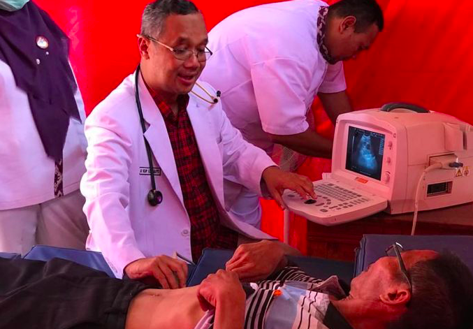 PERIKSA: Momen dr H Muchamad Nur Aziz SpPD saat memeriksa warga yang melakukan cek kesehatan di wilayah Jawa Tengah. Foto diamail sebelum pandemi pada 2019. (foto: ist)
