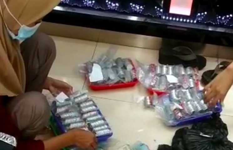 MENGHITUNG: Uang receh yang dibawa Kakek Januri, seorang pengemis ’kaya raya’ yang membeli emas. (gambar: instagram/andreli48)