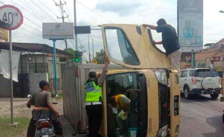SELAMAT: Truk boks AA 1868 QK yang dikemudikan KHM, 36, warga Desa Dasih, Kecamatan Pakis, Kabupaten Magelang terguling. (foto: ist)