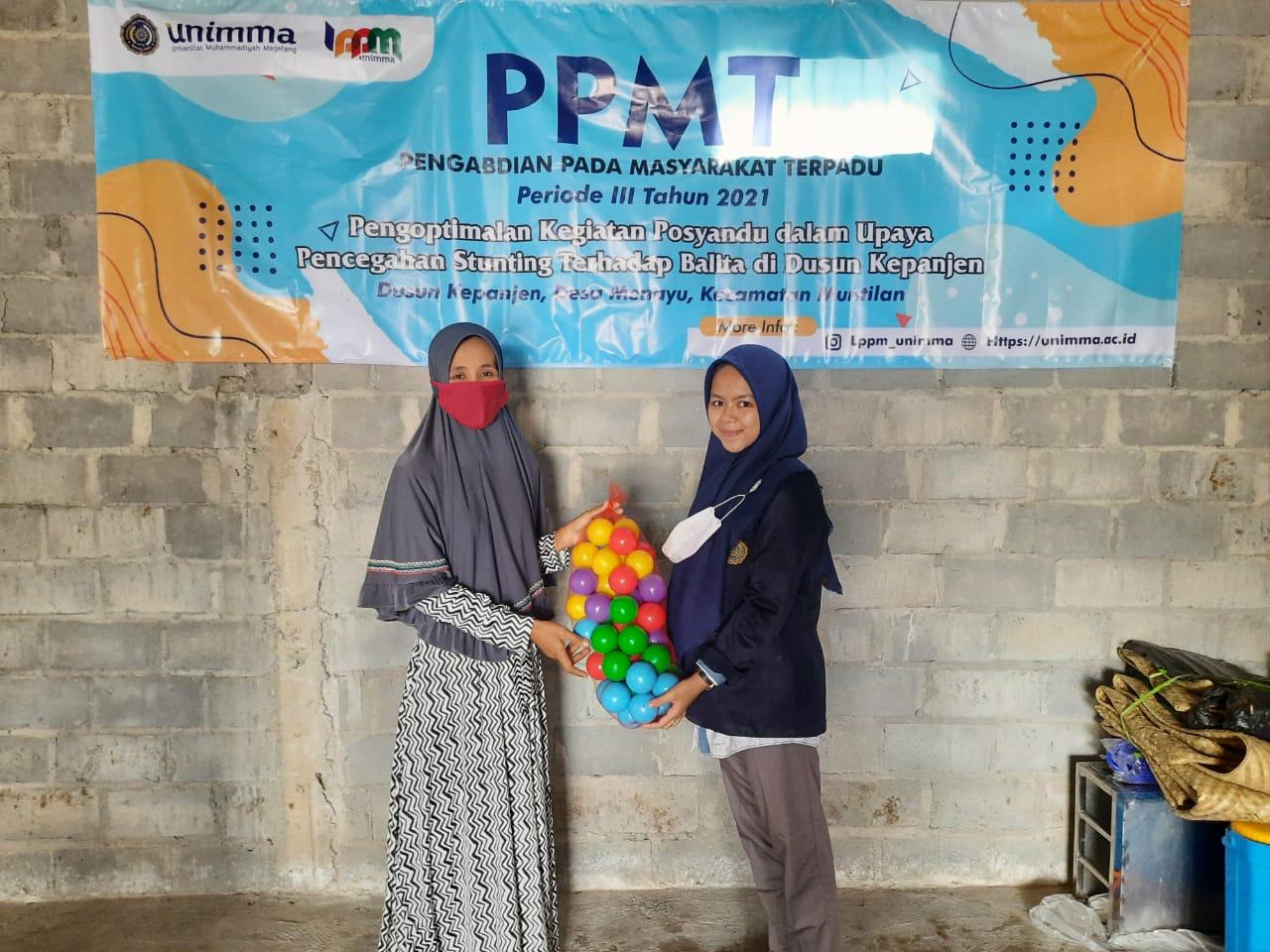 Penyerahan mainan anak oleh mahasiswa PPMT UNIMMA kepada Kades Posyandu Kenangan Kepanjen Muntilan