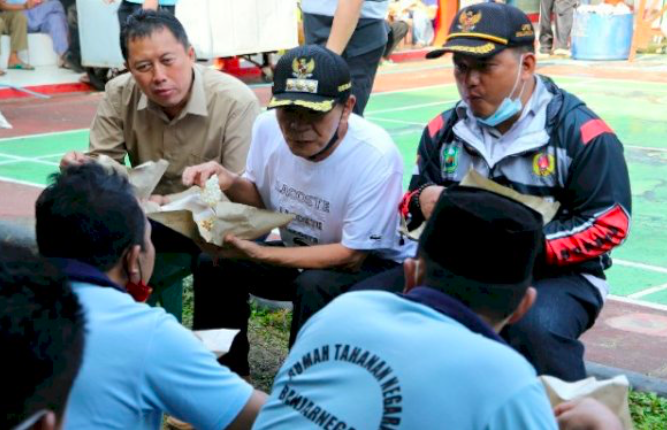 DEKAT: Bupati Budhi Sarwono (tengah) saat makan nasi bungkus bersama warga binaan Rutan Banjarnegara. (foto: ist)