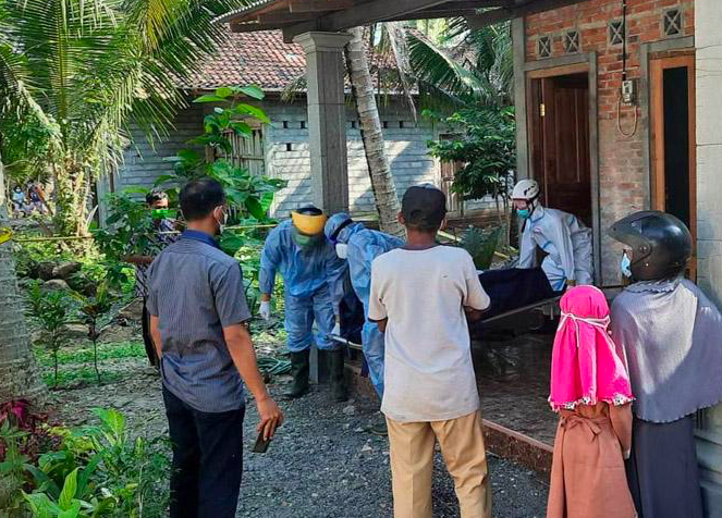 Jenazah PHT, 50, warga Jogjakarta dievakuasi petugas ber-APD lengkap. (foto: ist)