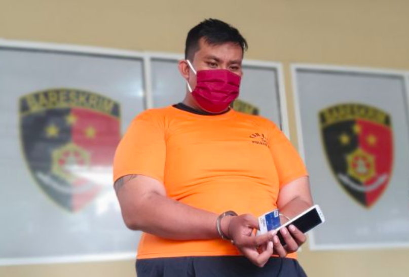 PENIPU: Tersangka IW, 29, berikut barang bukti kartu ATM dan HP. (foto: ist)