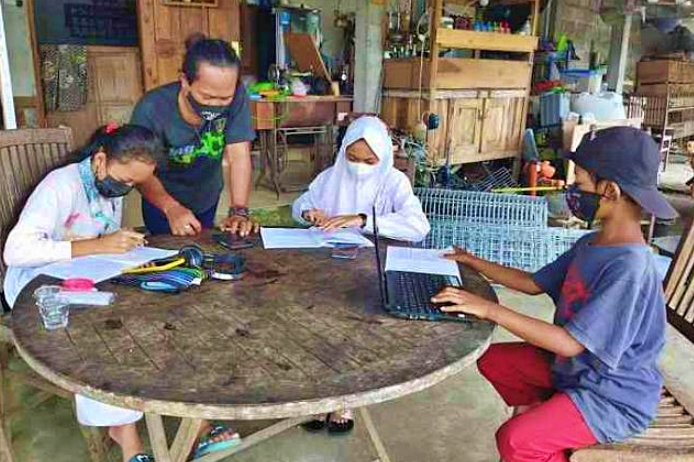 Seorang Seniman Magelang saat mendampingi anak anak belajar dengan akses internet gratis miliknya