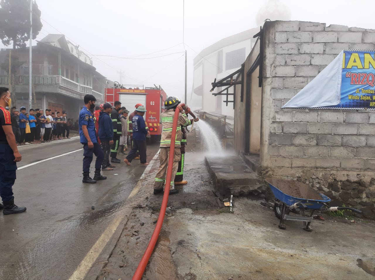 Petugas Damkar Kabupaten Magelang saat memadamkan api yang membakar warung di Sawangan