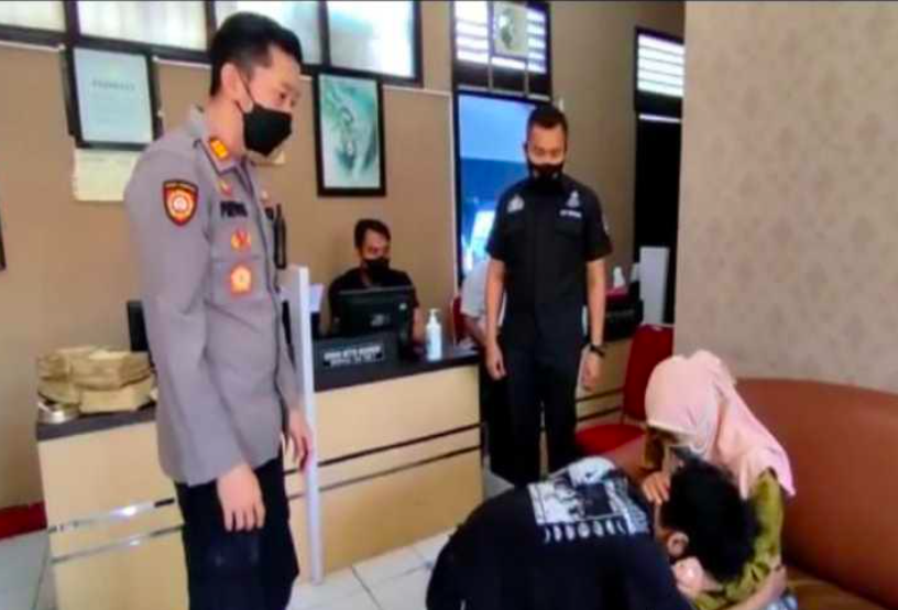TOBAT: MHJ bersimpuh di kaki Ibunya, MR, setelah menyesal menghajarnya. (foto: ist)