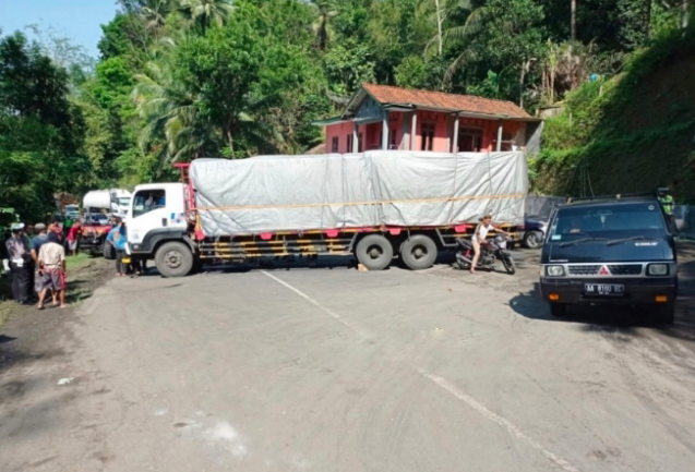 MACET: Truk container bermuatan bijih besi melintang di Jalan Purworejo-Magelang KM18. (foto: ist)