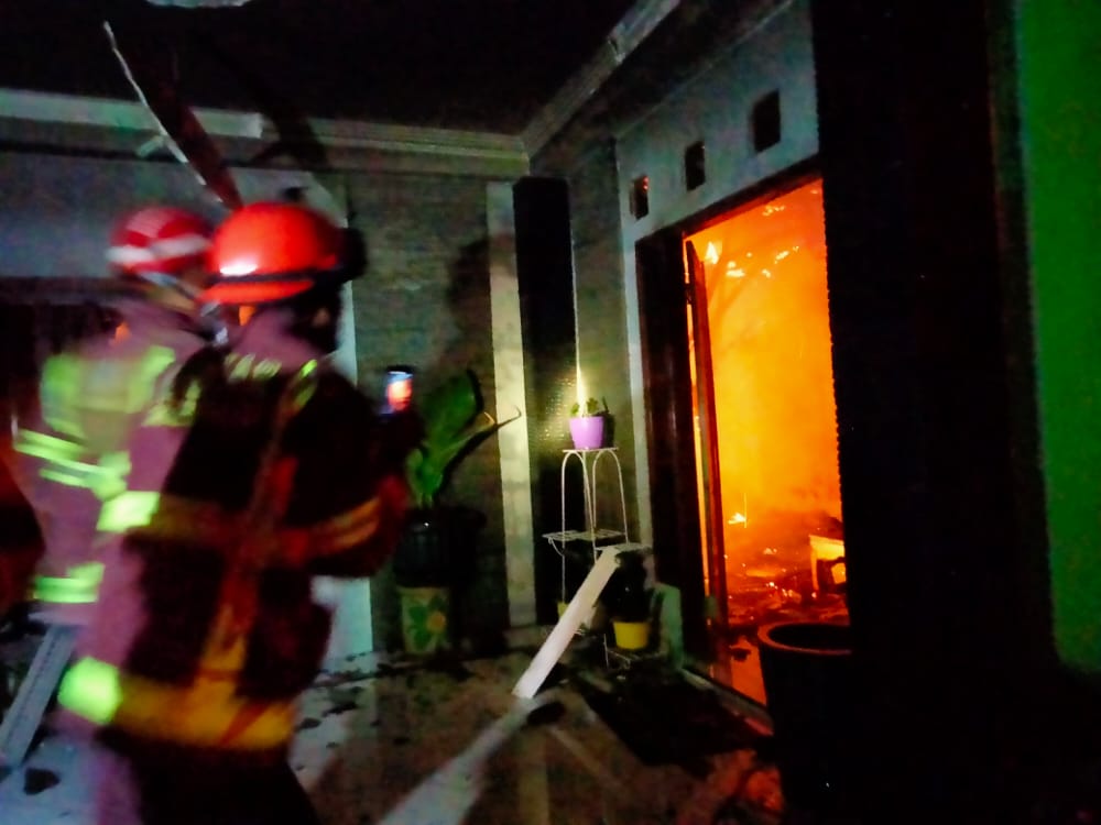 SEMPROT: Petugas Damkar Kabupaten Magelang memadamkan api yang membakar rumah dan mengancam bangunan sekitarnya. (foto: ist)