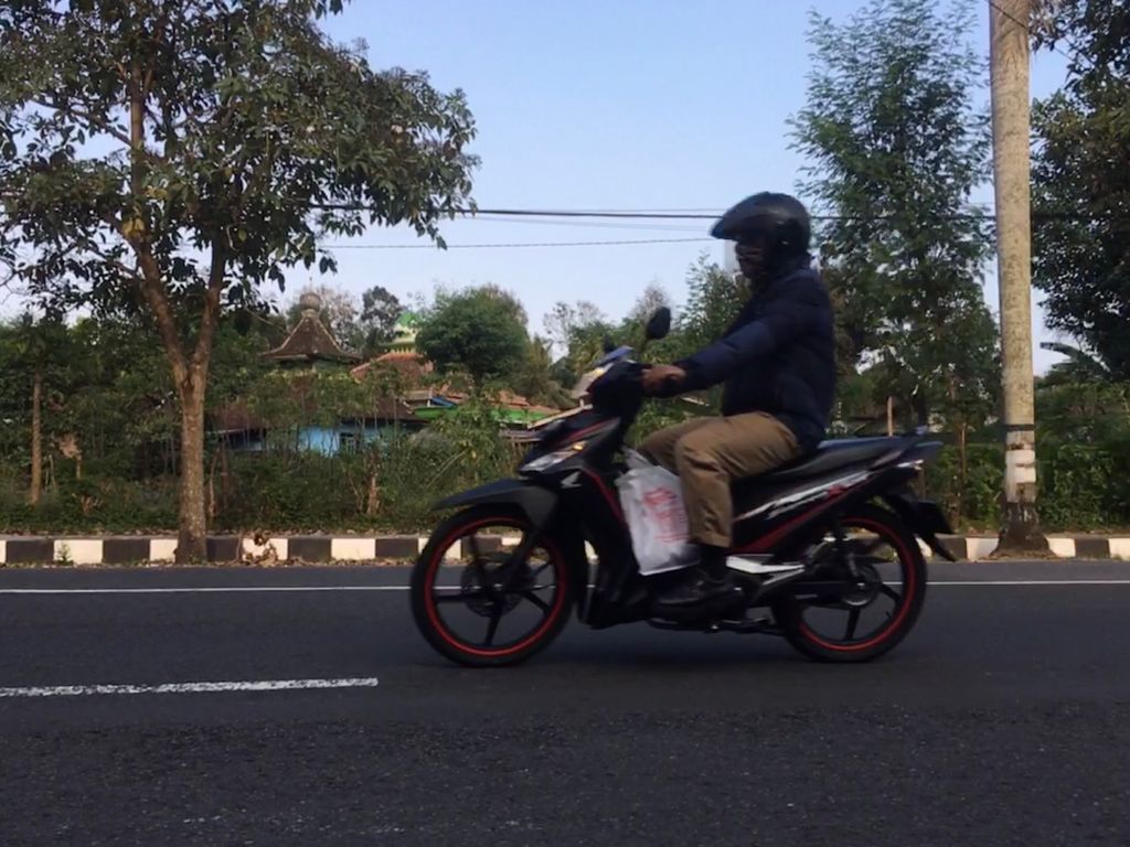 PULANG: PNS Pemkab Magelang melintas di Jalan Soekarno-Hatta dengan Honda Supra X 125. (foto: han)