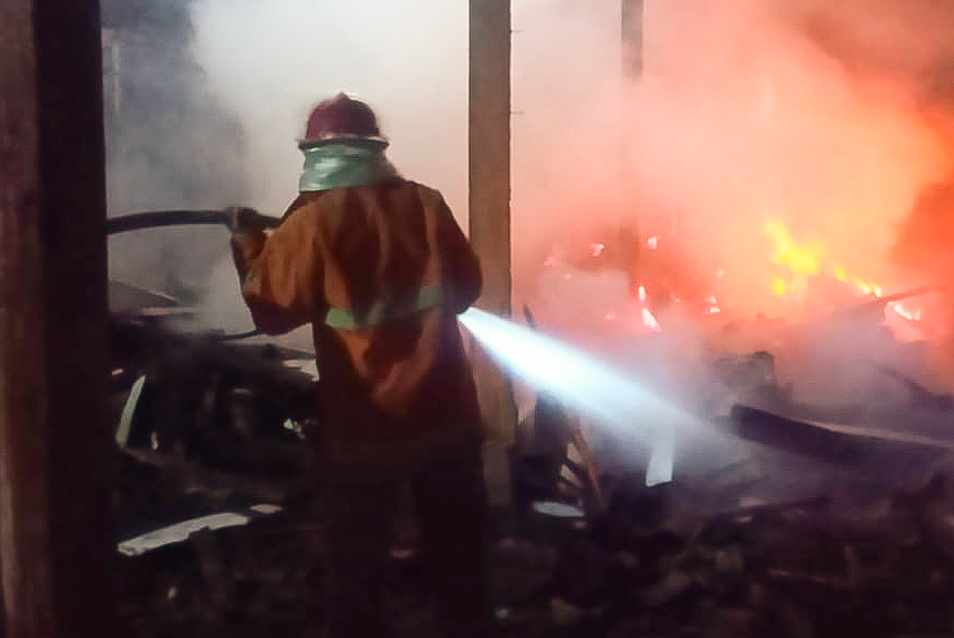 TERBAKAR: Petugas Pemadam Kebakaran Kabupaten Magelang berusaha menjinakkan api yang melahap rumah salah satu warga di Srumbung. (foto: ist)