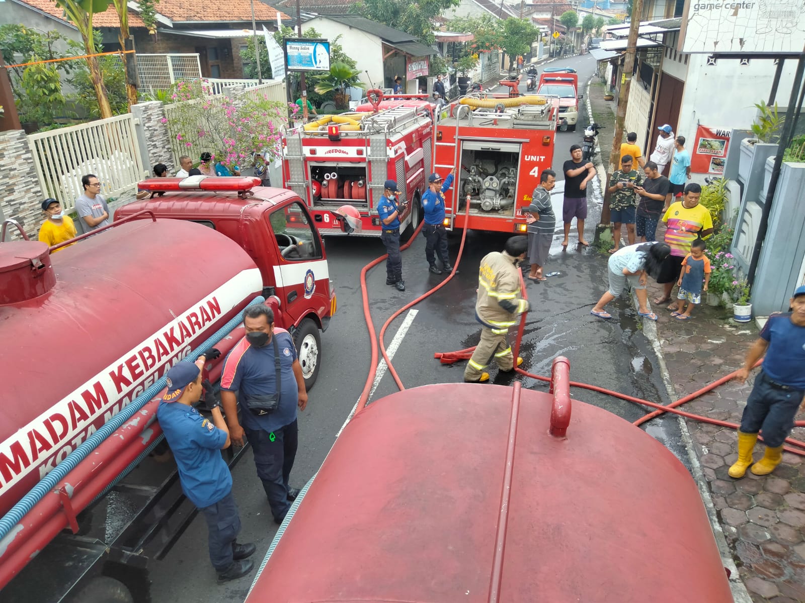 PASUKAN BIRU: Damkar Kota Magelang menerjunkan empat mobil untuk memedamkan api yang membakar sebuah rumah. (foto: ist)